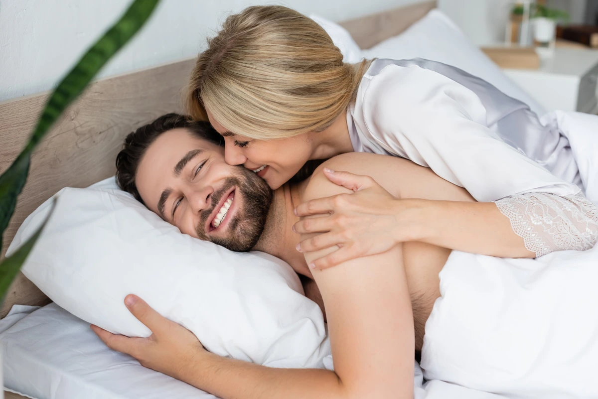 Mujer rubia sonriendo al lado del hombre