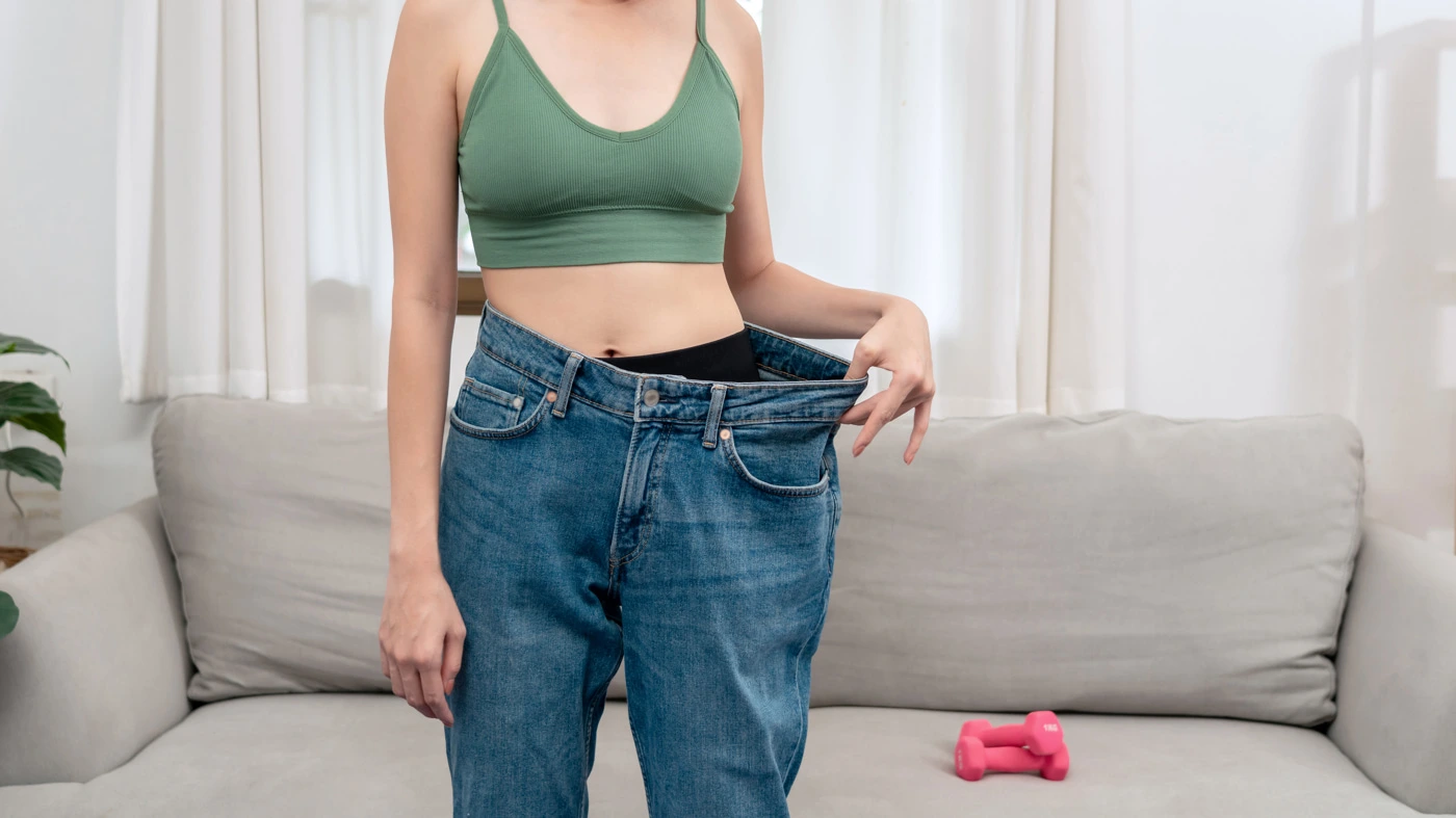 women holding her pants after she lost weight