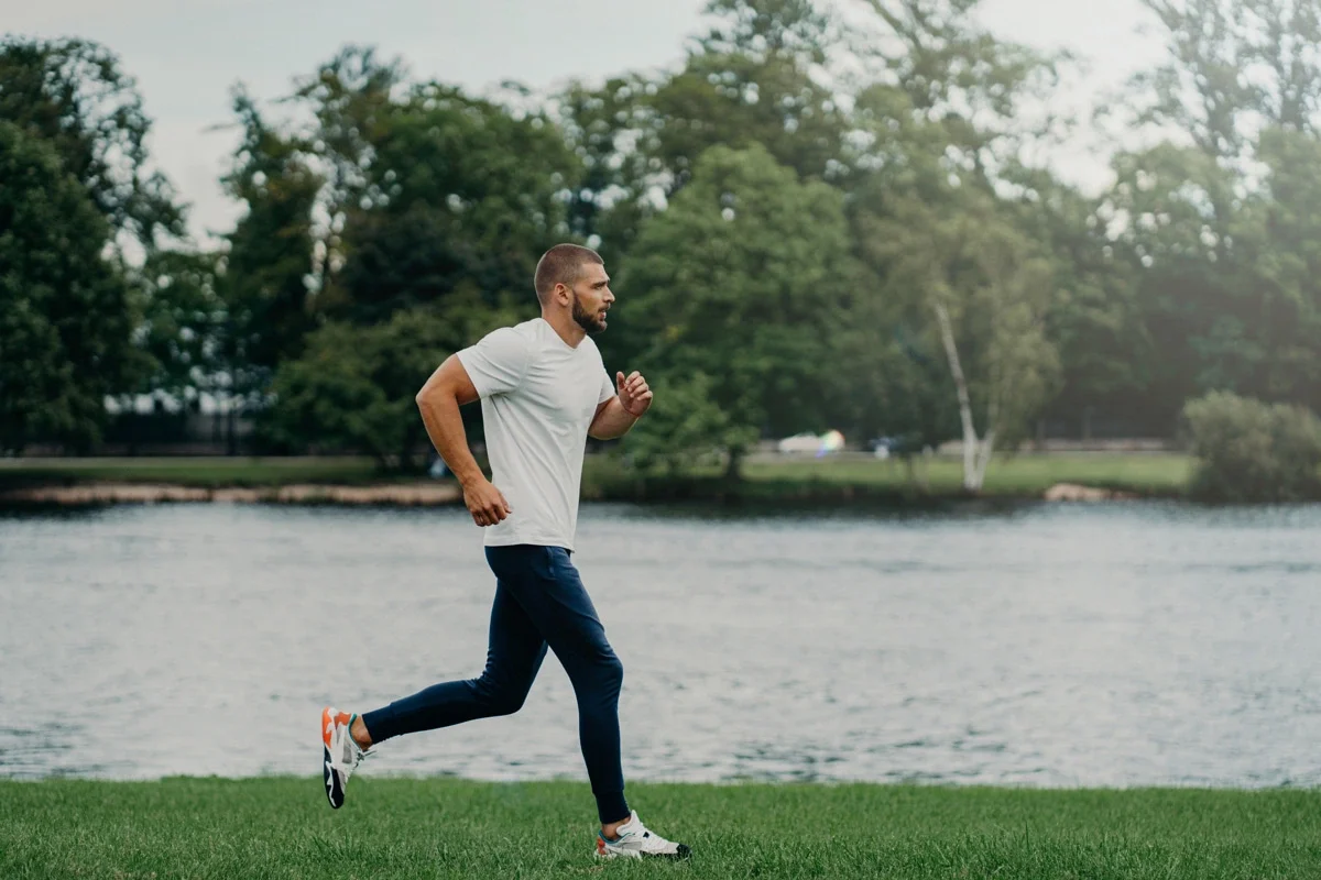 strong athlete running along beautiful landscape